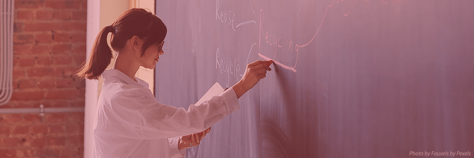 Female instructor writing on chalkboard
