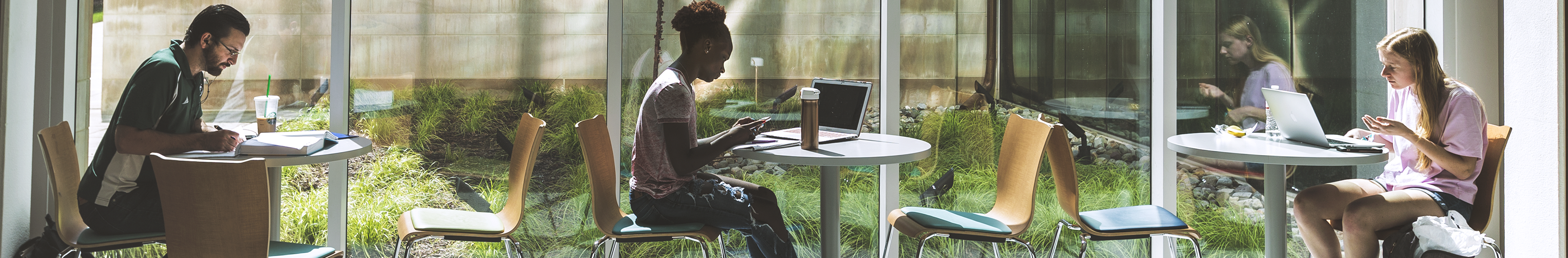 Students studying at tables in the Edward St. John Building 