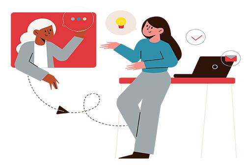 Two females have a discussion. One woman in a turquoise shirt and gray pants is leaning on a desk while the second a white haired woman with a grey sweater is on a screen.