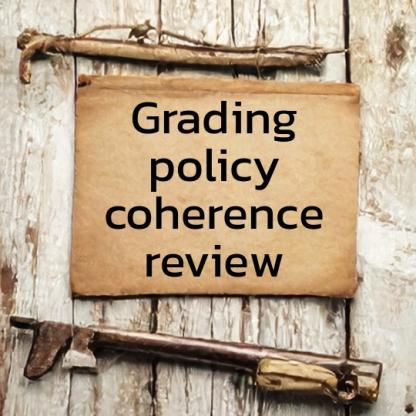 Rough wooden boards with vintage paper, looking like a hand-written field note, with the the words "grading policy coherence review" on it.